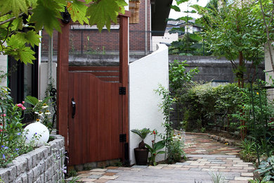 横浜にあるモダンスタイルのおしゃれな前庭 (日向、門扉、コンクリート敷き	、ウッドフェンス) の写真