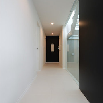 2階子世帯の廊下です。 奥には飾り棚、階段室との仕切りはガラスのカーテンです。 白にワンポイントで色を添えています。