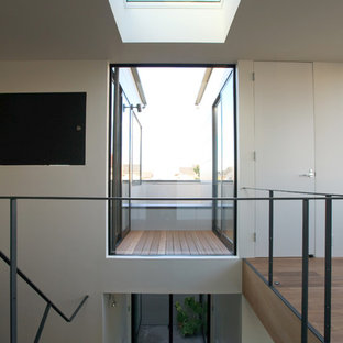Cette photo montre un couloir moderne de taille moyenne avec un mur blanc, un sol en bois foncé, un sol marron, un plafond en papier peint et du papier peint.