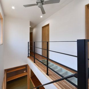 Inspiration för en liten funkis hall, med vita väggar, plywoodgolv och brunt golv