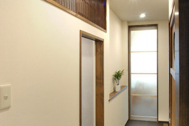 Ejemplo de recibidores y pasillos asiáticos de tamaño medio con paredes blancas, moqueta y suelo marrón