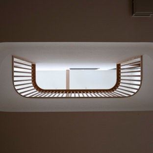 Cette photo montre un très grand couloir chic avec un mur blanc, un sol en bois clair, un sol beige, un plafond en papier peint et du papier peint.