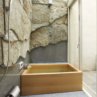 This is an example of a contemporary bathroom in Osaka with gray tile, multi-coloured walls and a japanese tub.