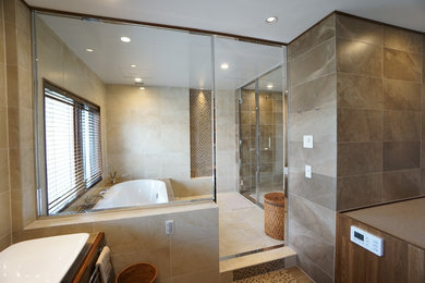 他の地域にある高級な広いモダンスタイルのおしゃれな浴室 (ドロップイン型浴槽、ベージュのタイル、セラミックタイル、開き戸のシャワー) の写真