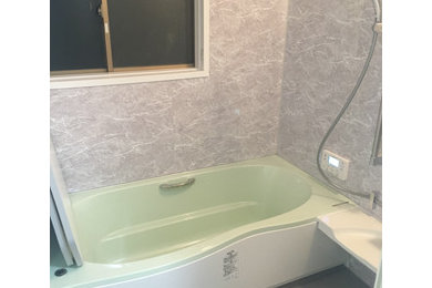 Idée de décoration pour une salle de bain avec un espace douche bain et un mur gris.