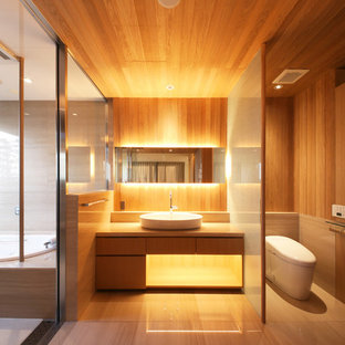 Esempio di una stanza da bagno etnica con ante lisce, ante in legno scuro, WC monopezzo, pareti marroni, lavabo a bacinella e pavimento beige