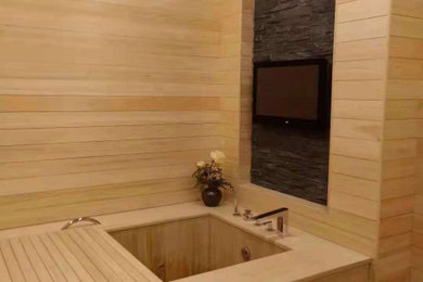 Imagen de cuarto de baño asiático con bañera japonesa, paredes beige y madera