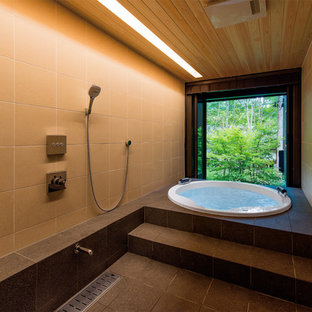 Asiatisches Badezimmer mit Whirlpool, beigefarbenen Fliesen, Porzellanfliesen, beiger Wandfarbe, Porzellan-Bodenfliesen und schwarzem Boden