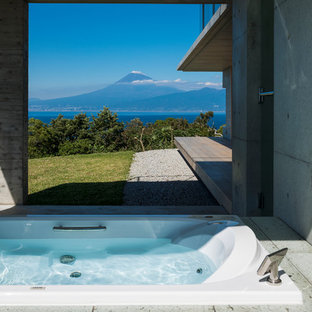 Modelo de cuarto de baño contemporáneo con bañera encastrada y paredes grises