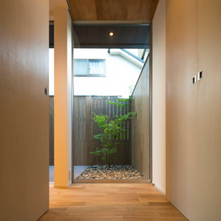 Réalisation d'une petit entrée nordique avec un couloir, un mur blanc, un sol en bois brun, une porte simple, une porte en bois foncé, un sol beige, un plafond en papier peint et du lambris.