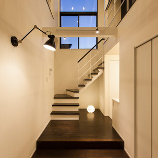 Cette photo montre une petit entrée rétro avec un couloir, un mur blanc, un sol en contreplaqué et un sol noir.