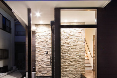 Diseño de hall asiático de tamaño medio con paredes beige, suelo de granito, puerta corredera, puerta de madera oscura y suelo negro
