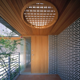 Exemple d'une entrée scandinave avec un sol en carreau de terre cuite, une porte simple et une porte en bois clair.