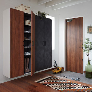 Immagine di un ingresso o corridoio industriale con pareti bianche, pavimento in legno massello medio, una porta singola, una porta in legno bruno e pavimento marrone