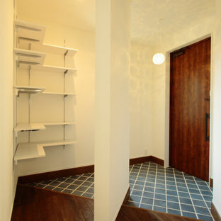Cette image montre une entrée avec un mur blanc, un sol en carreau de terre cuite, une porte simple, une porte en bois foncé, un sol turquoise, un plafond en papier peint et du papier peint.