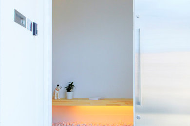 Foto de puerta principal moderna con paredes blancas, suelo de cemento, puerta corredera, suelo gris, madera y papel pintado