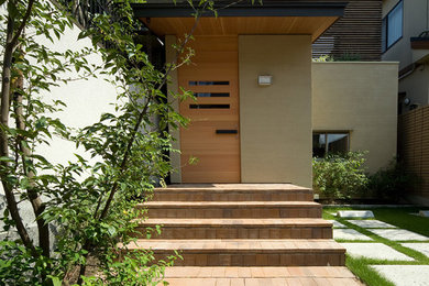 Ejemplo de puerta principal asiática con puerta simple y puerta de madera clara
