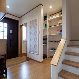Inspiration pour un hall d'entrée avec un mur blanc, un sol en contreplaqué, une porte simple, une porte marron, un sol marron, un plafond en papier peint et du papier peint.