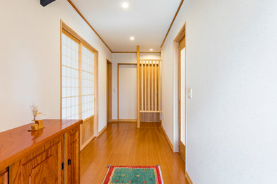 Modelo de hall de estilo zen con paredes blancas y suelo negro