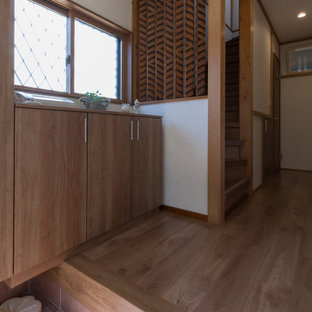 Exemple d'une petit entrée moderne avec un couloir, un mur blanc, un sol en carreau de terre cuite, une porte simple, une porte en bois brun, un sol orange et un plafond en papier peint.