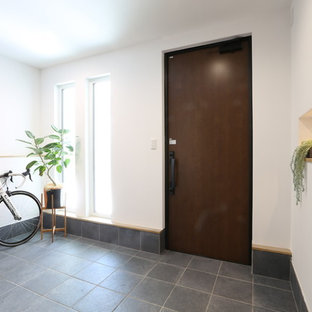 Cette photo montre une entrée moderne avec un couloir, un mur blanc, une porte simple, une porte marron et un sol vert.