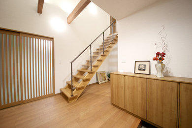 Ejemplo de entrada minimalista con paredes blancas, suelo de madera en tonos medios y suelo marrón
