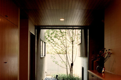 Modelo de hall clásico de tamaño medio con paredes beige, suelo de madera clara, puerta simple, puerta de madera en tonos medios, suelo marrón y madera