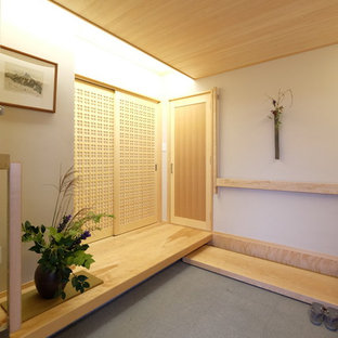 Cette photo montre une petit entrée asiatique avec sol en granite, une porte coulissante, une porte en bois clair, un couloir, un mur beige et un sol gris.