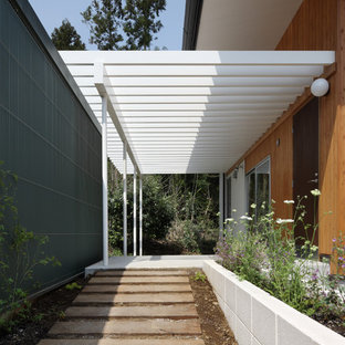 Ispirazione per un portico minimalista davanti casa con pavimentazioni in cemento e una pergola