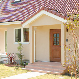 Idee per un grande portico nordico davanti casa con piastrelle e un tetto a sbalzo