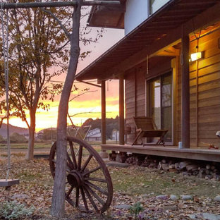Idee per un portico etnico di medie dimensioni e davanti casa con un tetto a sbalzo e parapetto in legno