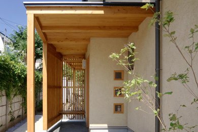 Foto di un grande portico minimalista davanti casa con piastrelle e un tetto a sbalzo