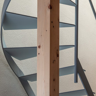 Cette photo montre un petit escalier courbe scandinave avec un garde-corps en métal.