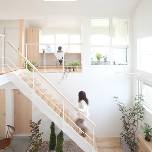 Cette photo montre un escalier droit scandinave de taille moyenne avec des marches en bois, des contremarches en bois et un garde-corps en métal.