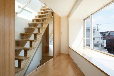 Foto de escalera recta minimalista con escalones de madera y barandilla de madera