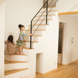 Ejemplo de escalera asiática con escalones de madera pintada y barandilla de varios materiales