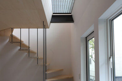 Foto de escalera en U de estilo zen pequeña sin contrahuella con escalones de madera y barandilla de metal
