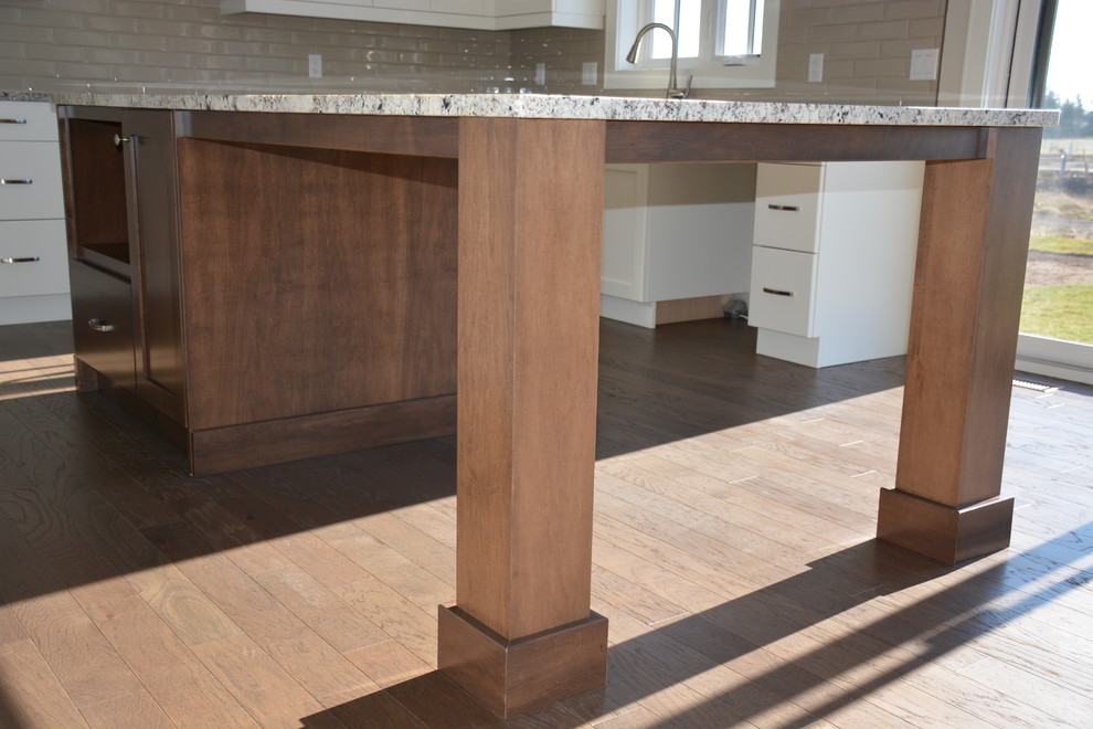 Example of a mid-sized transitional u-shaped light wood floor eat-in kitchen design in Toronto with a double-bowl sink, shaker cabinets, white cabinets, granite countertops, gray backsplash, subway tile backsplash, stainless steel appliances and an island