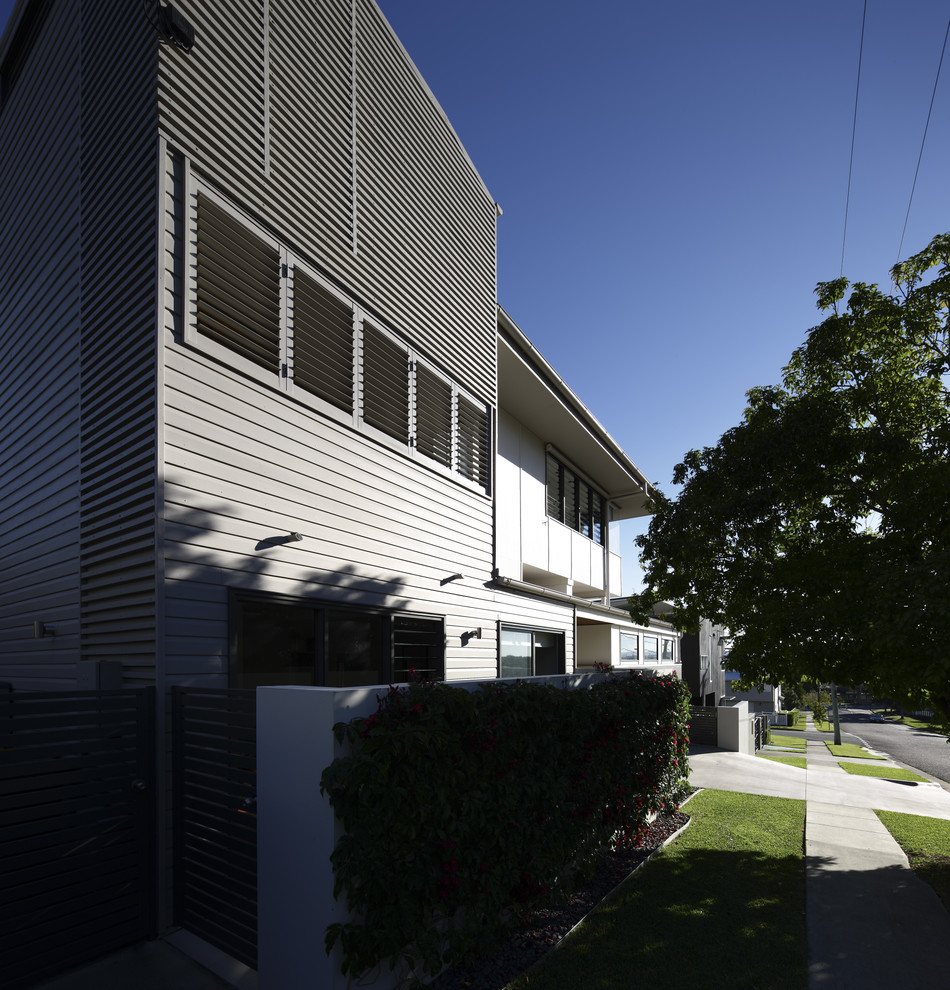 This is an example of a modern three-storey house exterior in Brisbane with a flat roof and a metal roof.