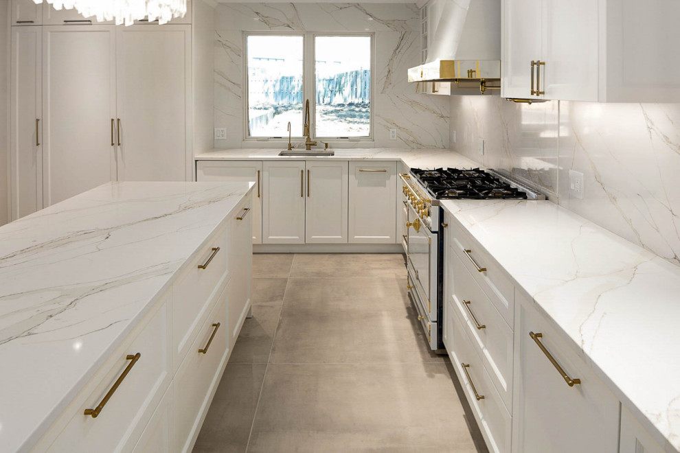 This is an example of a large transitional u-shaped eat-in kitchen in New York with a single-bowl sink, recessed-panel cabinets, white cabinets, quartz benchtops, white splashback, engineered quartz splashback, coloured appliances, porcelain floors, with island, brown floor, white benchtop and coffered.