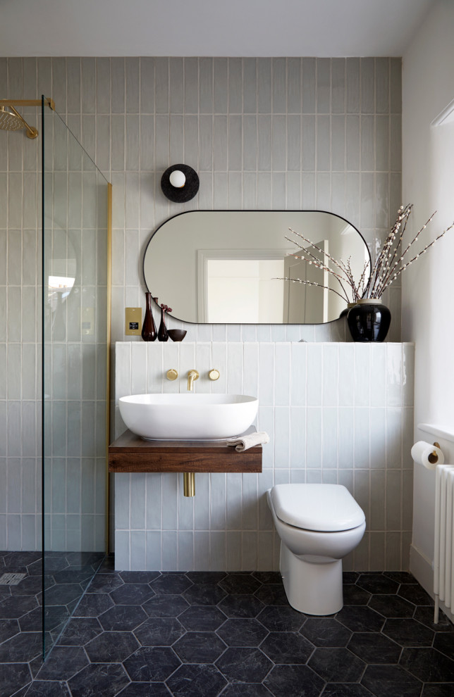 Inspiration for a contemporary master bathroom in London with an open shower, green tile, porcelain tile, ceramic floors, black floor and a single vanity.