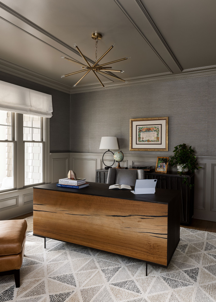 На фото: кабинет в стиле неоклассика (современная классика) с серыми стенами, темным паркетным полом, отдельно стоящим рабочим столом, коричневым полом, панелями на стенах и обоями на стенах с