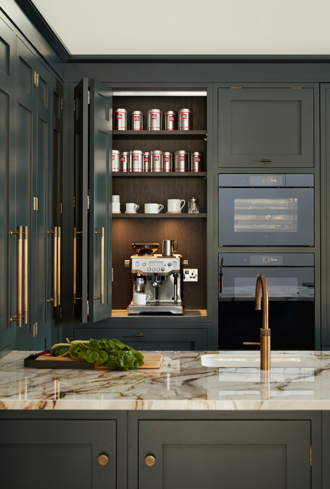 Foto di una grande cucina classica con lavello a vasca singola, ante in stile shaker, ante verdi, top in marmo, elettrodomestici da incasso, pavimento in laminato, pavimento marrone e top bianco