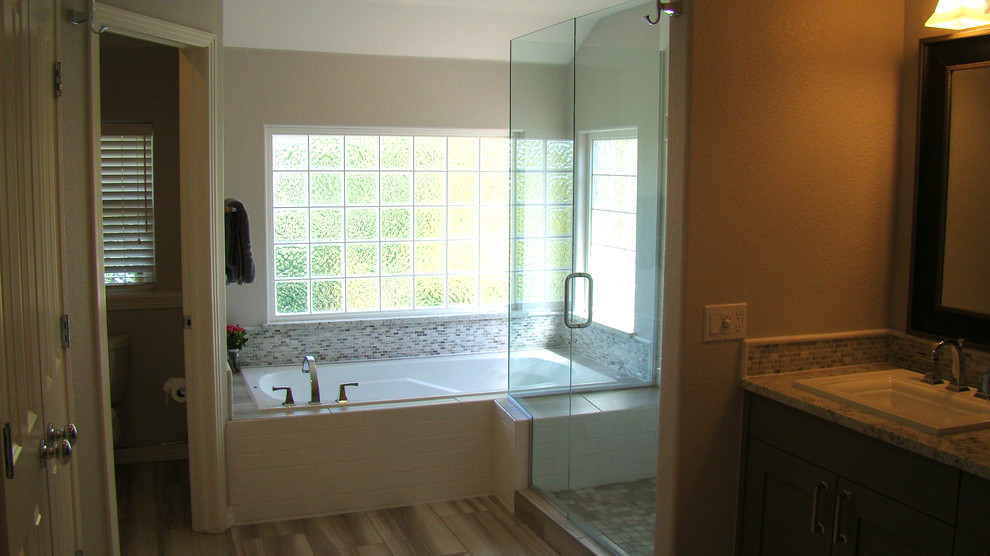 Large transitional master gray tile and mosaic tile porcelain tile drop-in bathtub photo in Denver with a drop-in sink, shaker cabinets, gray cabinets, granite countertops and gray walls