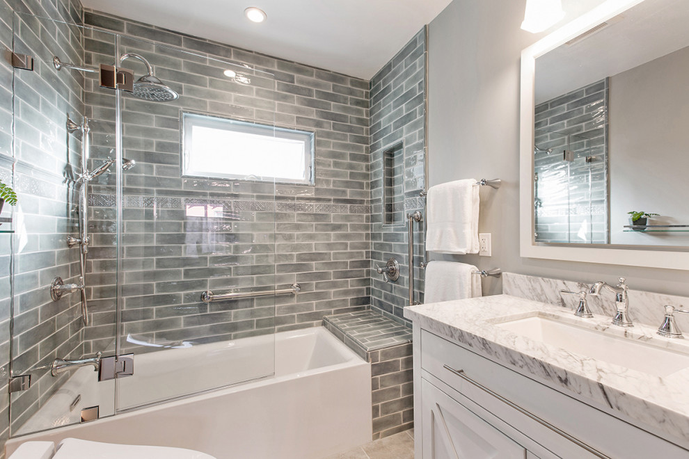 Small traditional bathroom in San Francisco with white cabinets, an alcove tub, a shower/bathtub combo, a one-piece toilet, grey walls, porcelain floors, an undermount sink, marble benchtops, grey floor, a hinged shower door, white benchtops, a double vanity and recessed-panel cabinets.