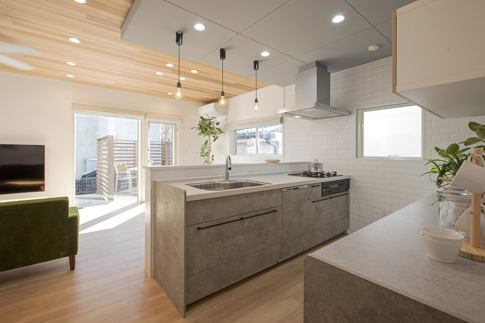 Idéer för att renovera ett mellanstort minimalistiskt vit linjärt vitt kök med öppen planlösning, med en undermonterad diskho, grå skåp, bänkskiva i koppar, vitt stänkskydd, stänkskydd i porslinskakel, plywoodgolv, en köksö och beiget golv