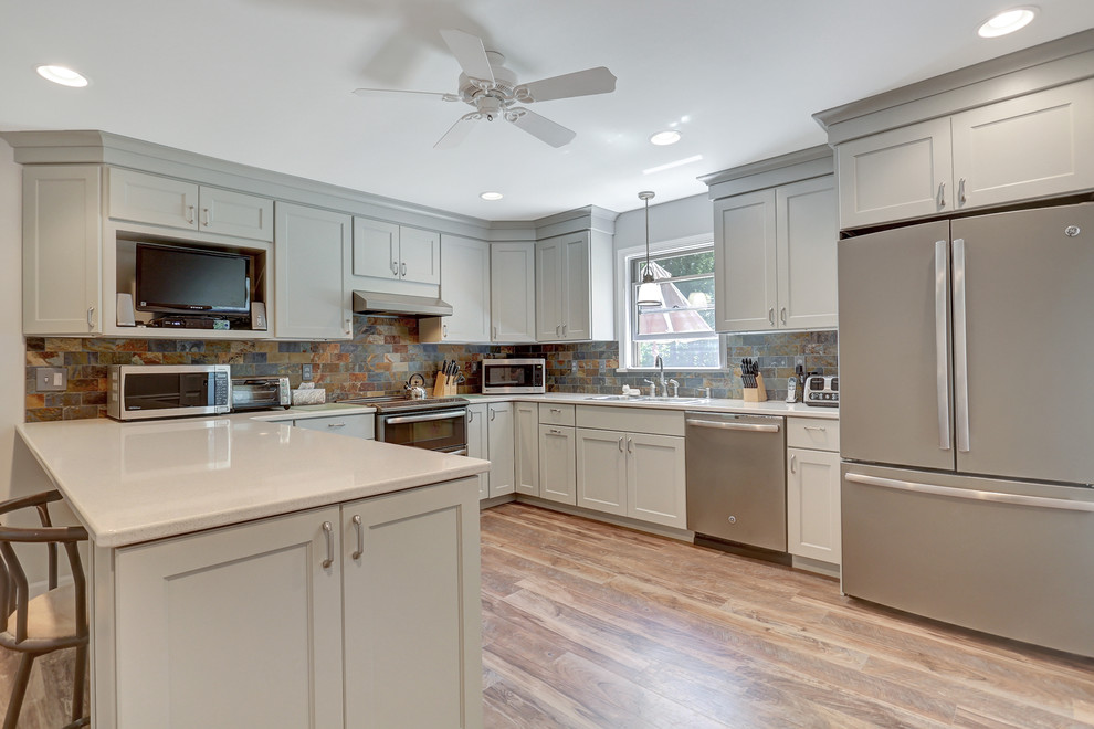 Inspiration for a large eclectic u-shaped medium tone wood floor enclosed kitchen remodel with shaker cabinets, beige cabinets, quartz countertops, multicolored backsplash, stone tile backsplash, stainless steel appliances and no island