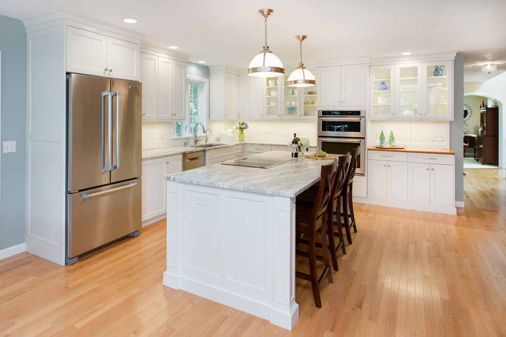 Eat-in kitchen - transitional l-shaped light wood floor eat-in kitchen idea in Boston with an undermount sink, recessed-panel cabinets, white cabinets, quartzite countertops, white backsplash, subway tile backsplash, stainless steel appliances and an island