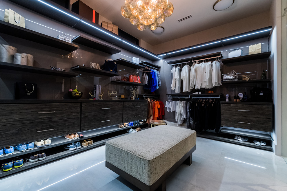 Inspiration for an expansive modern dressing room in Miami with flat-panel cabinets, dark wood cabinets, marble floors and grey floor.