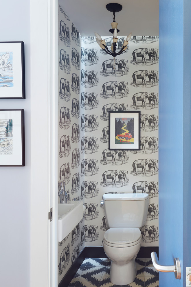 Photo of a transitional powder room in New York with a two-piece toilet and grey walls.